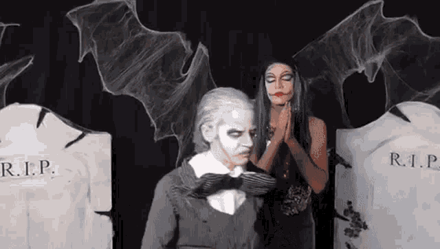a man and a woman in halloween costumes are posing for a picture .