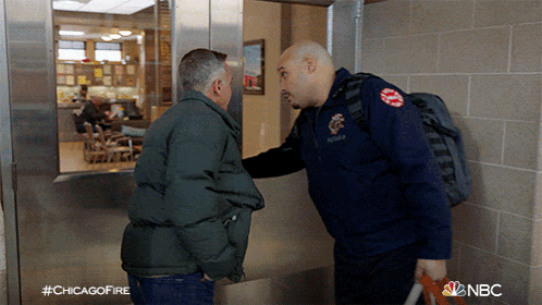 two men are standing next to each other in a hallway with the hashtag #chicagofire on the bottom