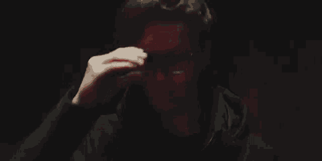 a close up of a man 's face in the dark with a red light shining on his face .