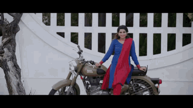 a woman is sitting on a motorcycle that says royal enfield on it