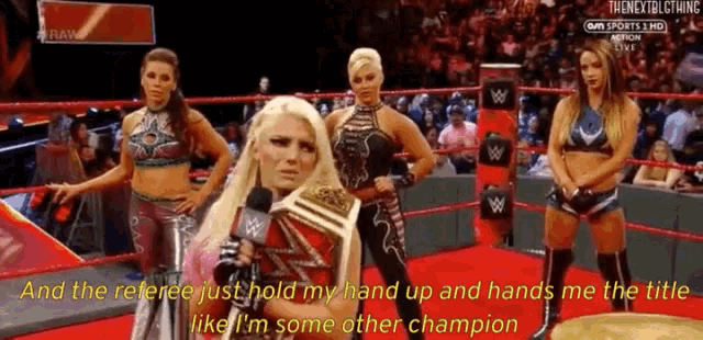 a woman in a wrestling ring holds a trophy and says " and the referee just hold my hand up "