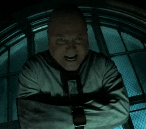a man in a straight jacket with his arms crossed looks angry