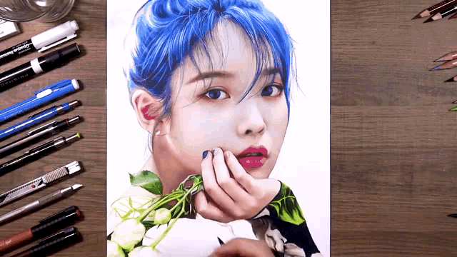 a drawing of a woman with blue hair is on a wooden table