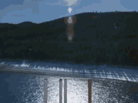 a row of metal poles are reflected in the water