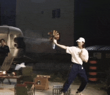a man is holding a fan and a bottle of water