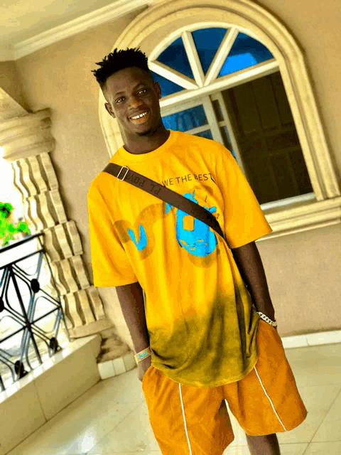a young man wearing a yellow t-shirt that says we the best