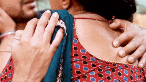 a man is putting his hand on a woman 's back .