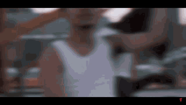a blurry picture of a man wearing a white tank top