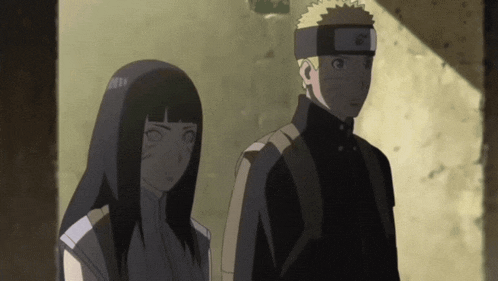 a man and a woman are standing next to each other and the man is wearing a headband with the letter n on it