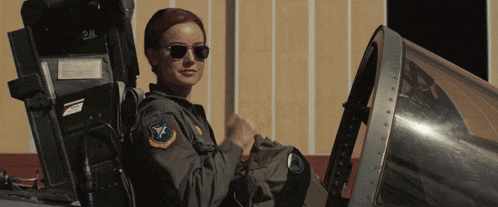 a woman in a military uniform is sitting in a plane