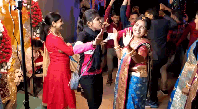 a group of people are dancing in a room with flowers .