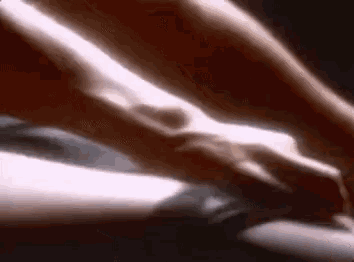 a close up of a person 's hand on another person 's leg in a blurry photo .
