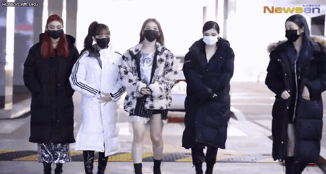 a group of women wearing face masks are standing next to each other