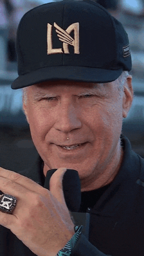 a man wearing a black hat with la written on it