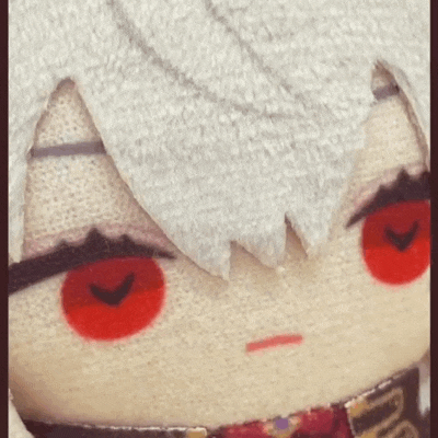 a close up of a stuffed animal with red eyes and a scarf around its neck