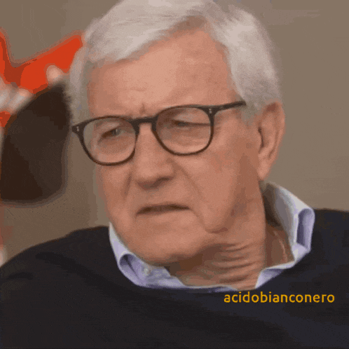a man wearing glasses and a blue shirt has the name acidobianconero on the bottom right