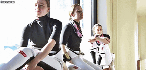 three women are sitting in a row and one of them has a red sticker on her leg that says toro