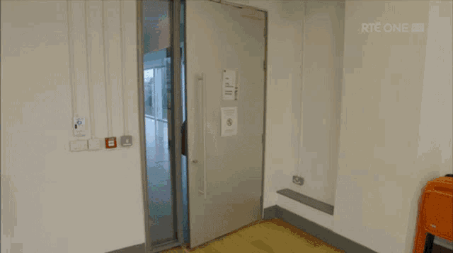 a man in a white tank top is walking through a door with rte one written on the bottom