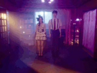 a man and a woman are dancing in a dark room with purple lights