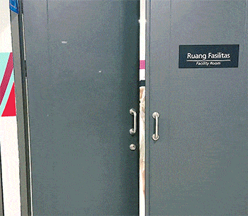 a woman in a white dress is standing in ruang fasilitas facility room
