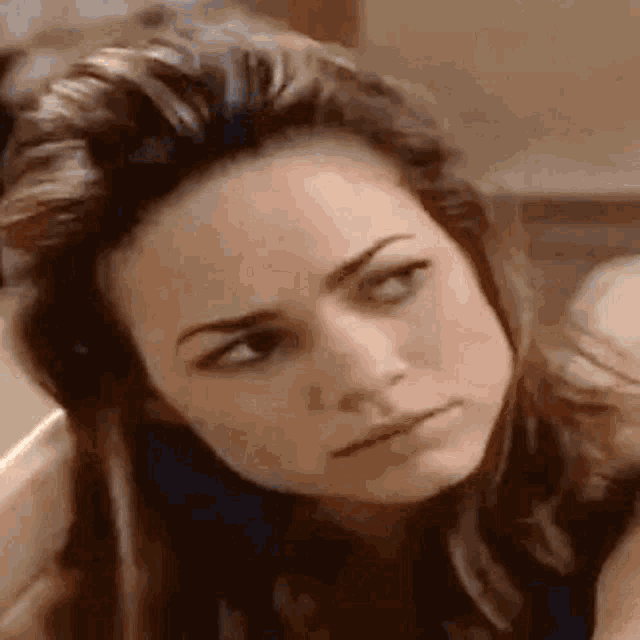 a close up of a woman 's face with a serious expression .
