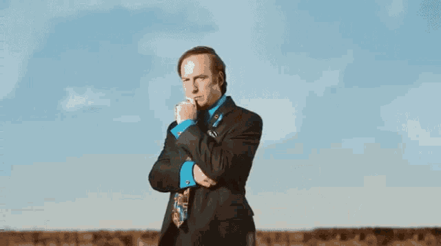 a man in a suit and tie stands in front of a bob odenkirk sign