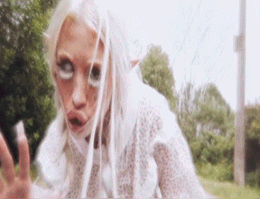 a woman with white hair and eyes is making a funny face .