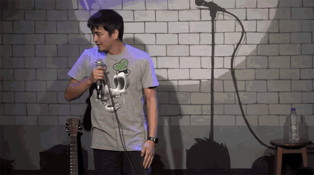 a man singing into a microphone while wearing a shirt with a skull and a heart on it