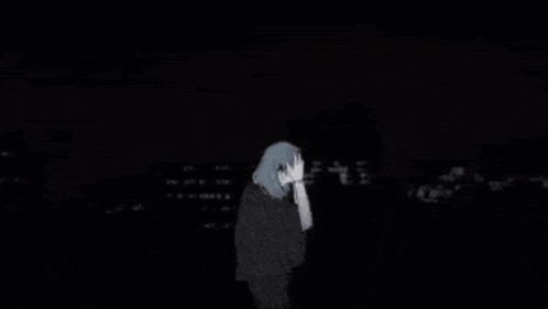 a person is standing in the dark with their hands on their head .