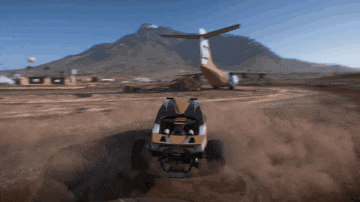 a buggy is driving on a dirt road with a plane in the background