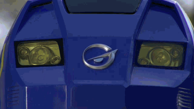a close up of a car 's headlights with the letter g on the front