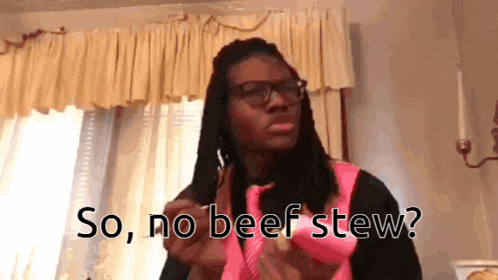a man with dreadlocks says so no beef stew in front of a window