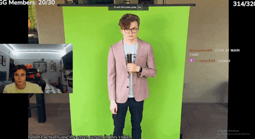 a man in a pink jacket is standing in front of a green background