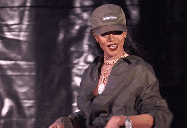 a woman wearing a supreme hat and a green jacket
