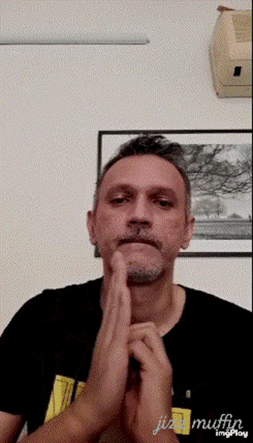 a man with a beard and mustache is praying with his hands folded