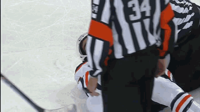 a hockey referee with the number 34 on the back of his jersey