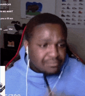 a man wearing headphones is making a funny face while sitting in front of a microphone .