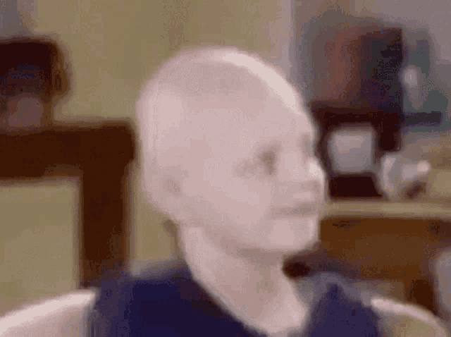 a blurry picture of a baby sitting in a chair .