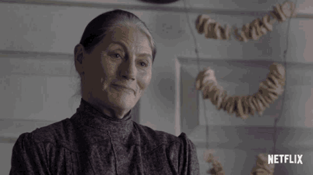 an older woman is smiling in front of a netflix banner