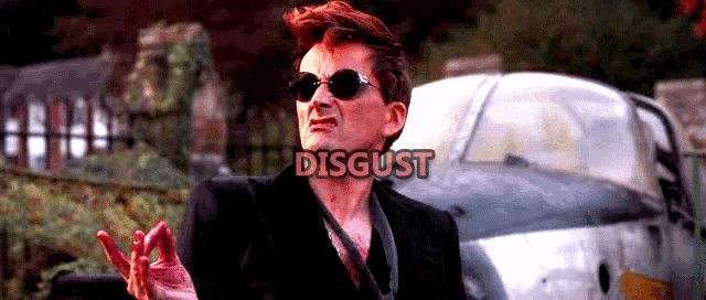 a man wearing sunglasses stands in front of a car with the word disgust written above him