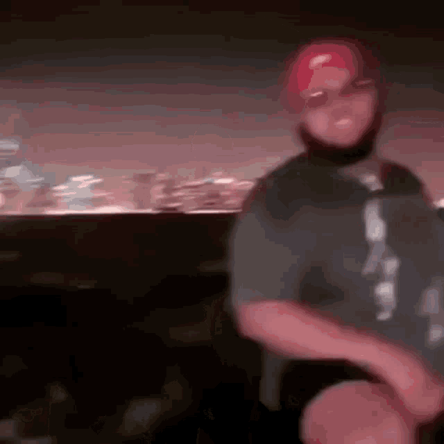 a blurry picture of a man wearing a mask and a hat .