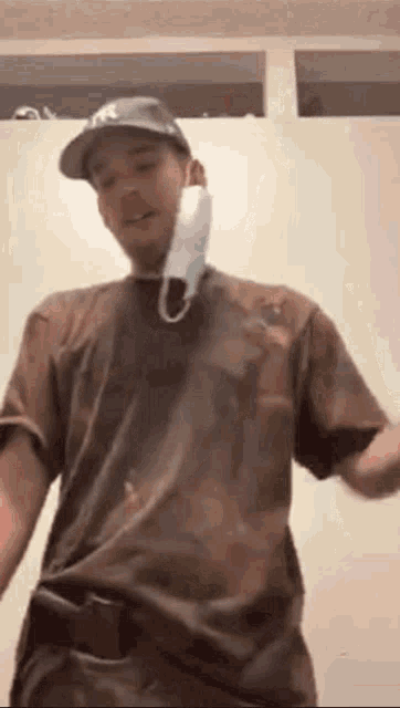 a man wearing a hat and a mask is dancing in a room .