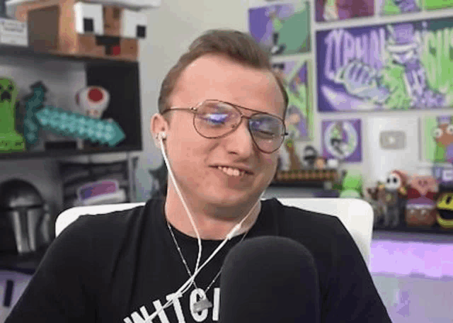 a man wearing glasses and headphones is sitting in front of a microphone in a room .