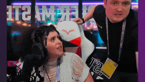 a man petting a woman 's head in front of a sign that says t2 on it