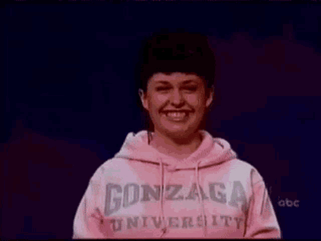 a woman wearing a pink sweatshirt with gonzaga university on it