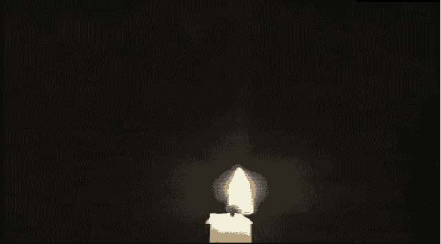 a person lighting a candle with a lighter in the dark