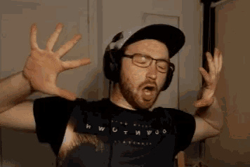 a man wearing glasses and headphones is making a funny face with his hands up