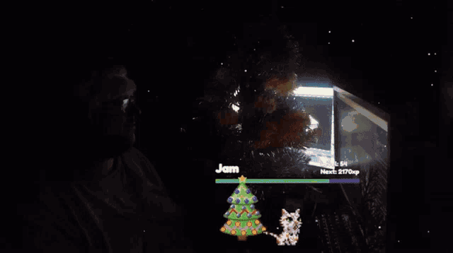 a man wearing a santa hat holds a christmas tree in front of a computer screen that says merry christmas