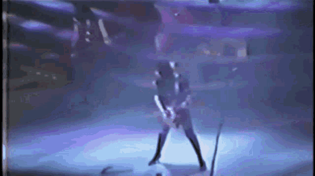 a man is playing a guitar on a stage with a microphone