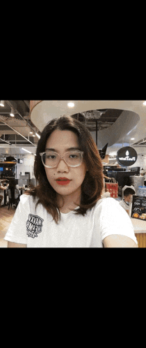 a woman wearing glasses and a t-shirt that says ' maya street ' on it